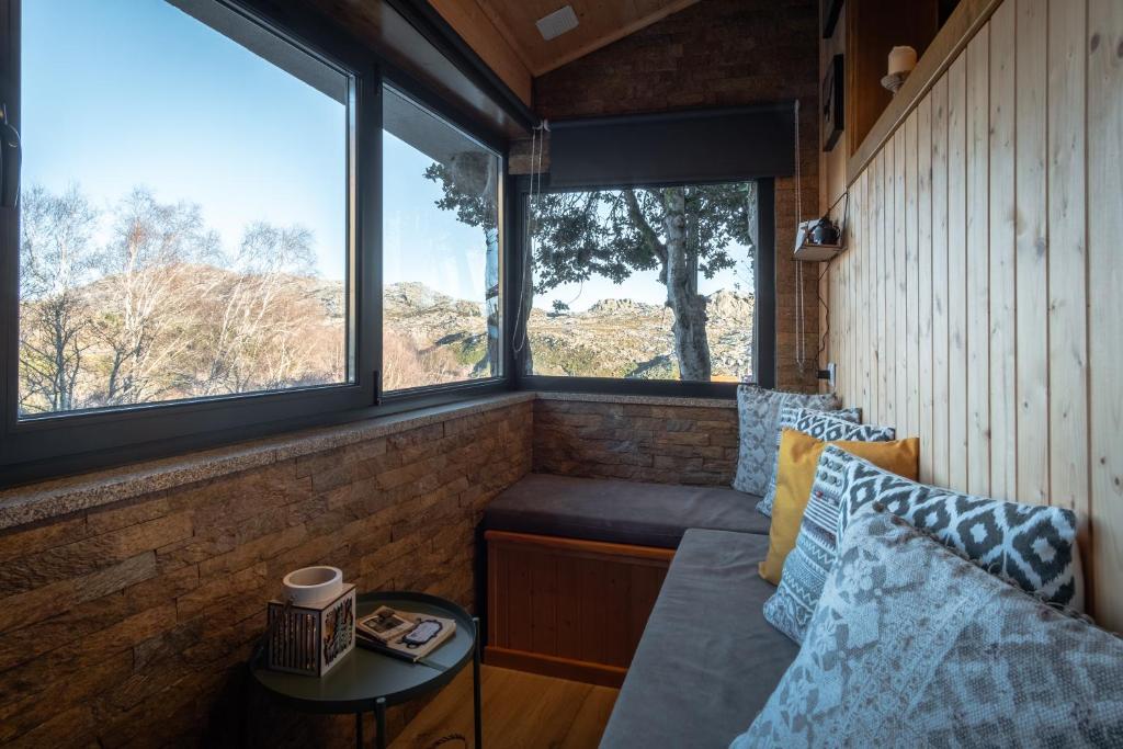 a room with a couch and two windows at Casa do Azevim in Gavieira