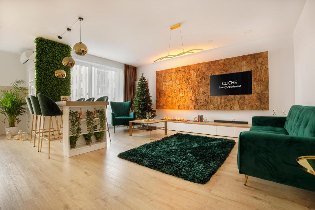 a living room with a green couch and a tv at Cliché Luxury Apartment in Braşov