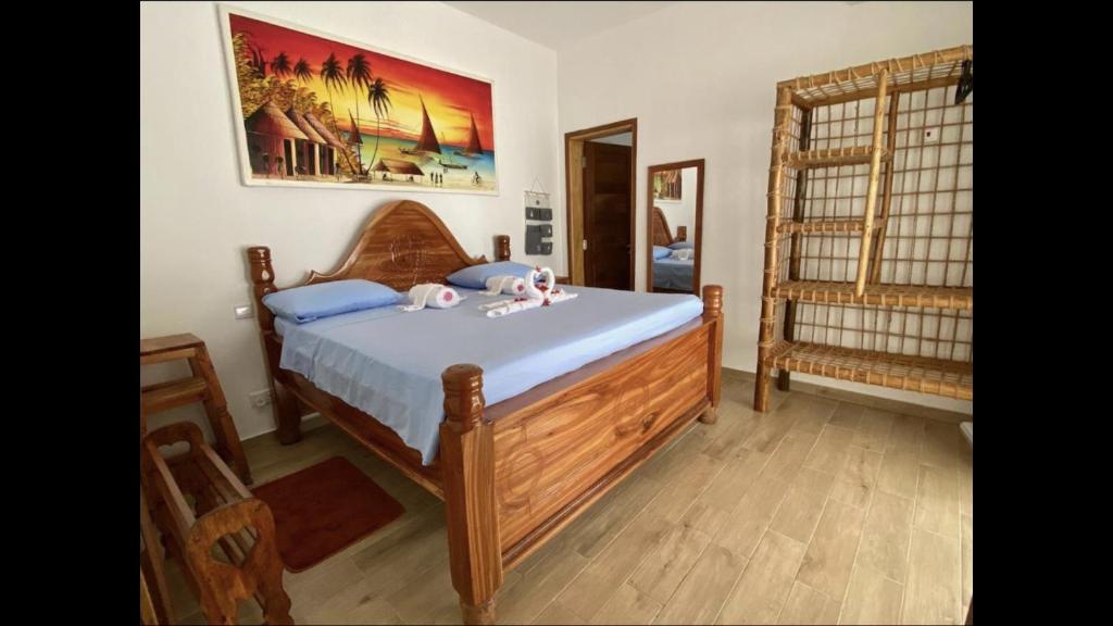 a bedroom with a wooden bed and a crib at Villa Thamani Zanzibar in Pwani Mchangani