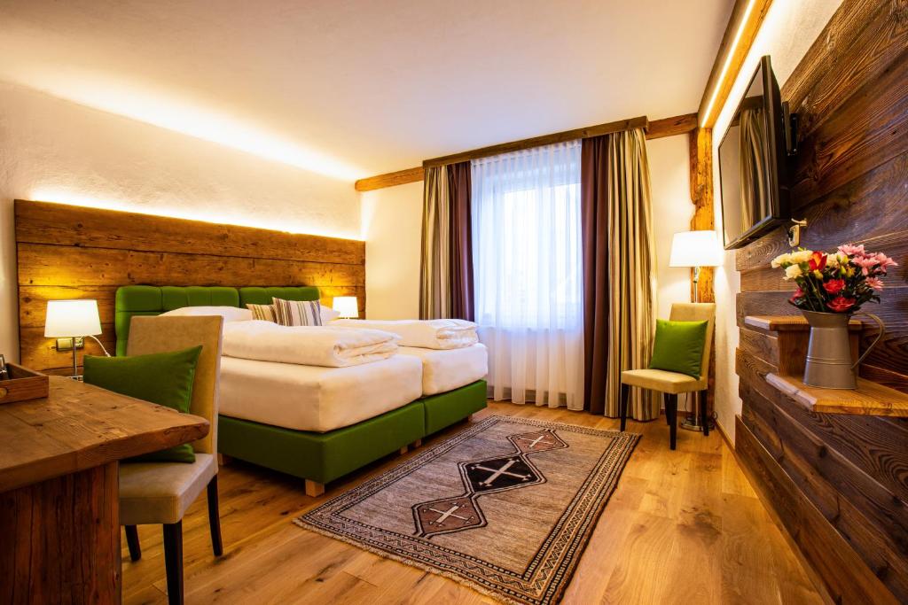 a hotel room with a bed and a table and chairs at Gasthof Lend-Platzl in Graz