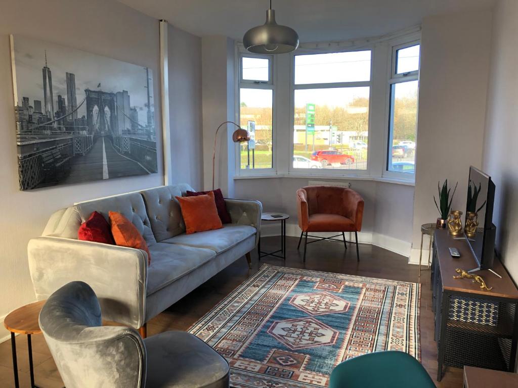 a living room with a blue couch and chairs at Coventry Modern House, Private Parking, A45 A46, Sleeps 6, by EMPOWER HOMES in Whitley