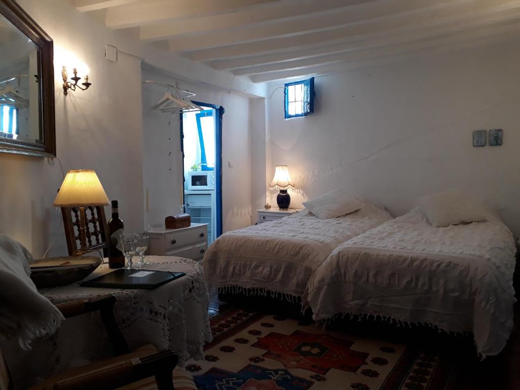 a bedroom with two beds and a table and a window at Guesthouse La Tienda Cómpeta 21b in Cómpeta