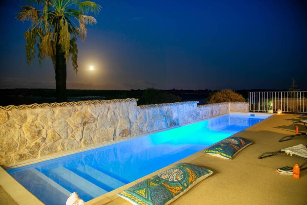 uma piscina num quintal à noite em Villa Ferrante em Marina di Ragusa