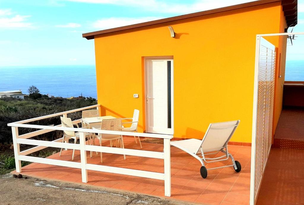 a yellow house with a balcony with a chair at Casita con Encanto in Frontera