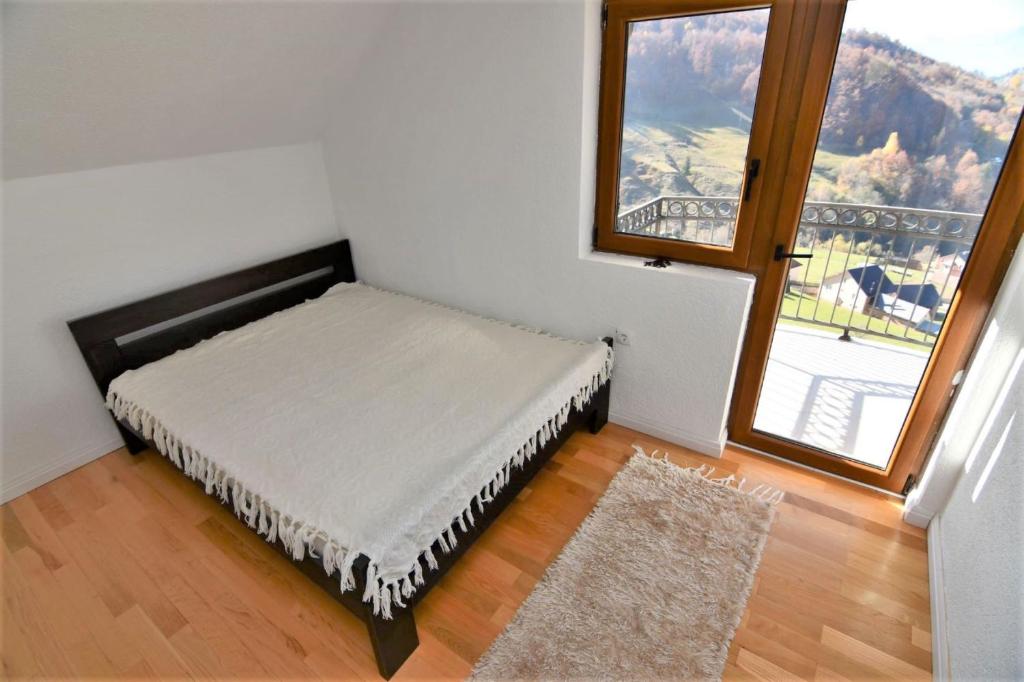 a bed in a room with a large window at 1060 Meet Eat Hike & Tour in Plav