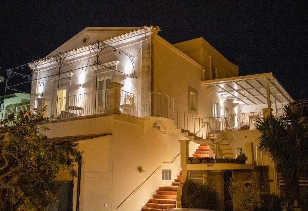 a building with stairs leading up to it at night at Salgari Uno in Marina di Ragusa