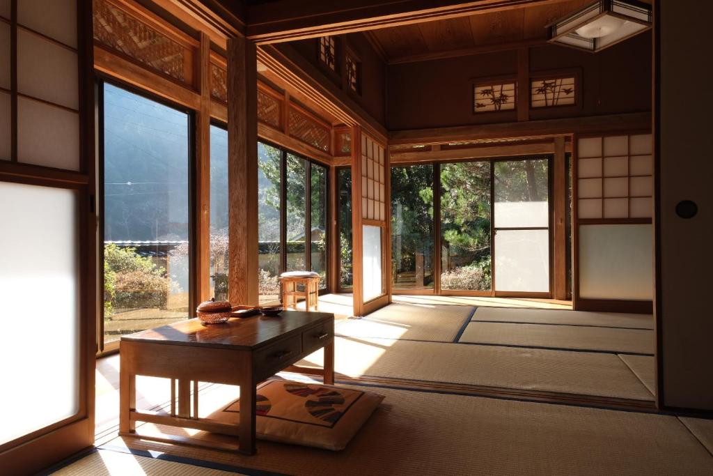 a room with a table and some windows at Shimanto Riverside Hideaway in Shimanto