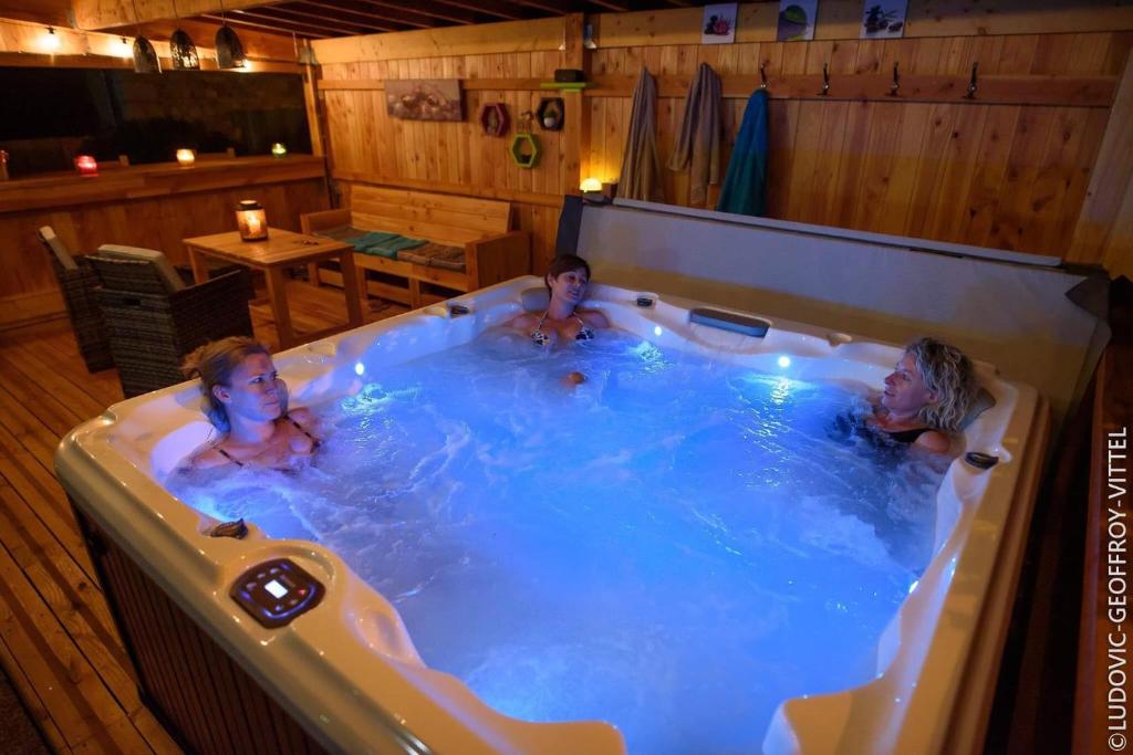 zwei Personen in einem Whirlpool in einem Restaurant in der Unterkunft Le Nid d'Alex Spa - Rando in Autigny-la-Tour