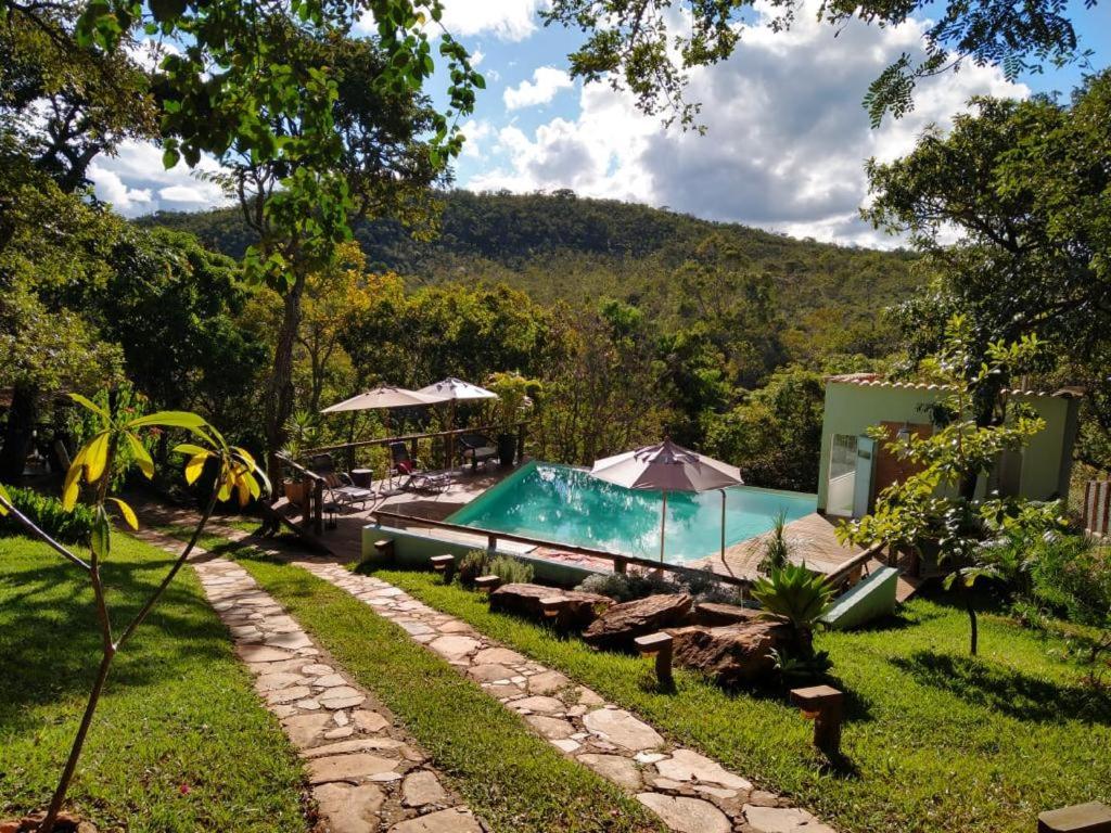 a house with a swimming pool in a yard at Pousada Santa Vila in Serra do Cipo