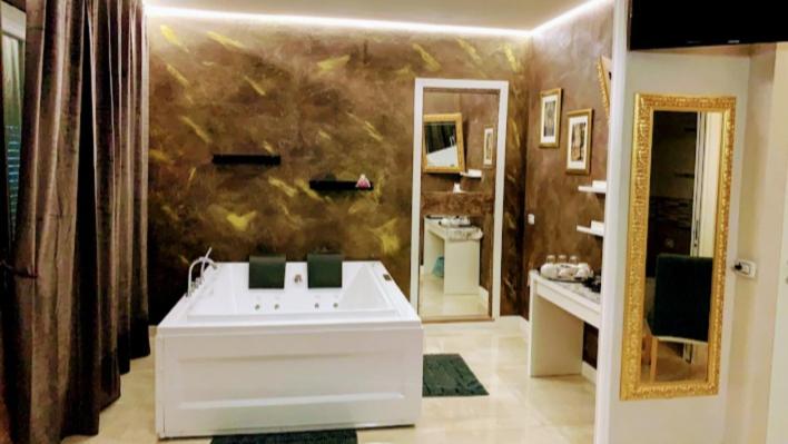 uma casa de banho com um lavatório branco e um espelho. em Gold House em La Spezia