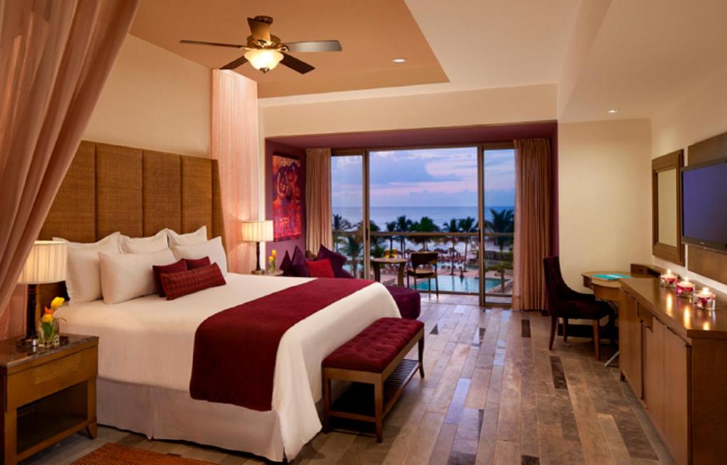 a hotel room with a bed and a balcony at Secrets Vallarta Bay Resort & SPA - Adults Only in Puerto Vallarta