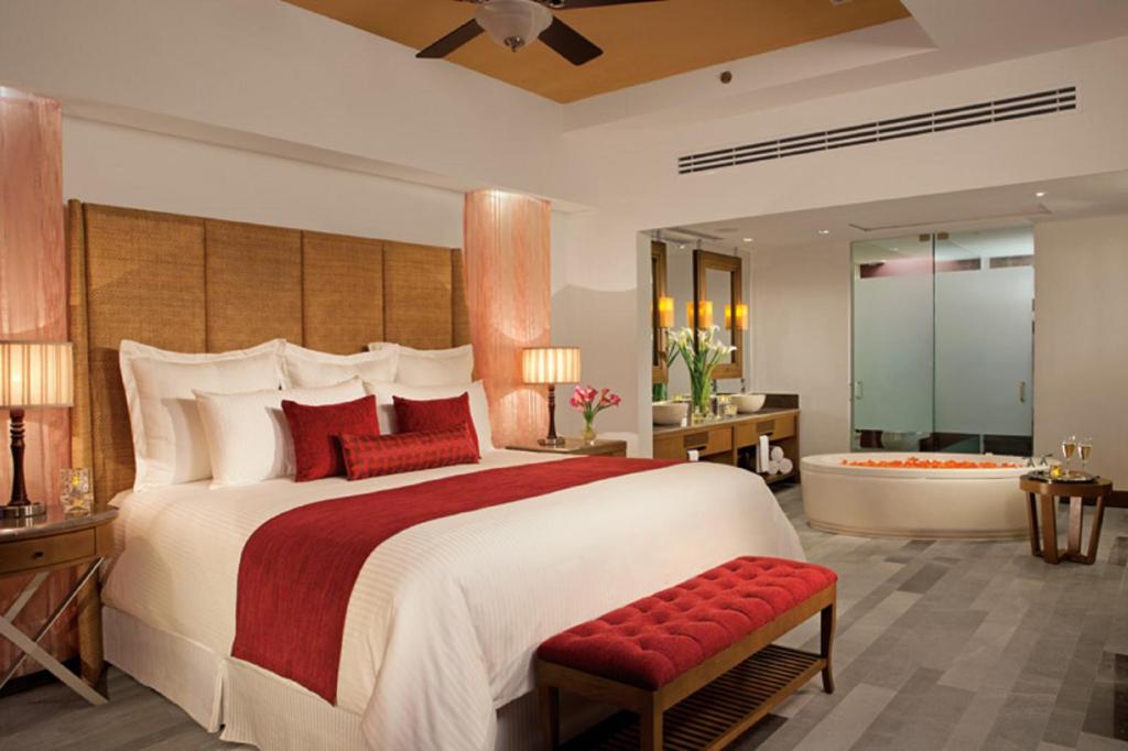 a bedroom with a large bed and a bath tub at Secrets Vallarta Bay Resort & SPA - Adults Only in Puerto Vallarta