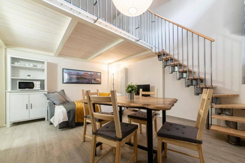 a living room with a table and a staircase at Casa Pinù in Bologna