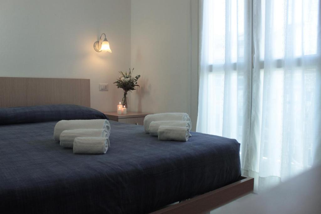een slaapkamer met een blauw bed met witte kussens bij Garnì Stella Marina in Cervia