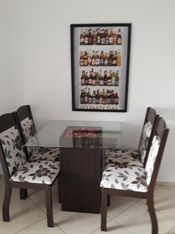 une salle à manger avec deux chaises et une table en verre dans l'établissement Apartamento Orquídea, à Campos dos Goytacazes