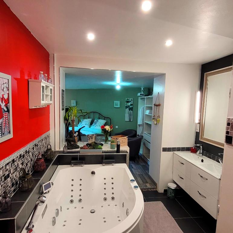 een badkamer met een groot bad in een kamer bij Suite Melody double balnéo, home-cinéma, terrasse à Dieppe in Dieppe