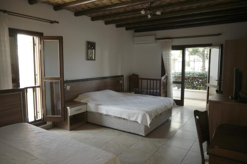 Schlafzimmer mit einem Bett und einem Spiegel in der Unterkunft Vouni King Hotel in Limnitis