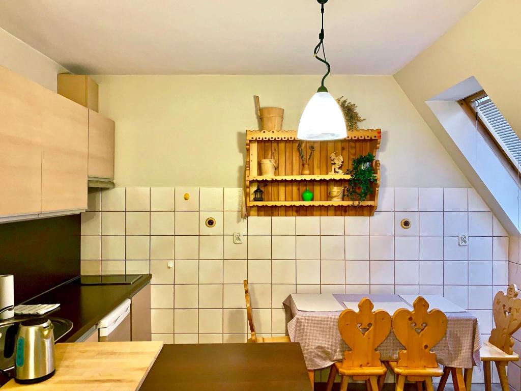 een keuken met een tafel en stoelen in een kamer bij APARTAMENT GIMNAZJALNA 8a (Maria Mąka) in Zakopane