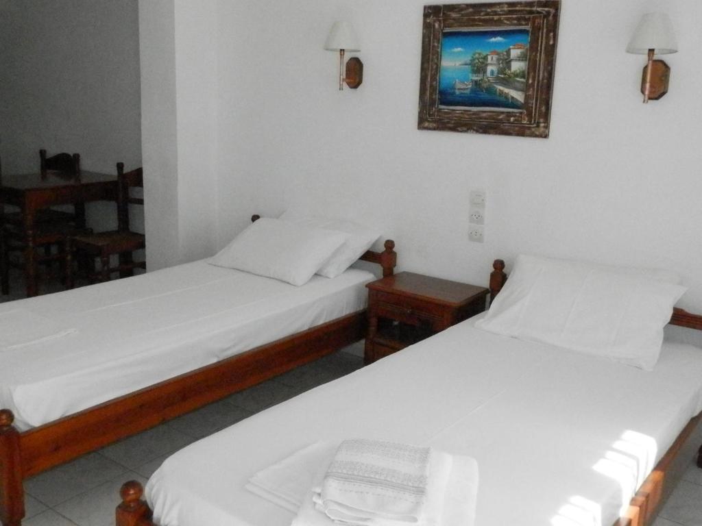 two beds in a room with a picture on the wall at Aeolos Hotel Apartments in Gythio