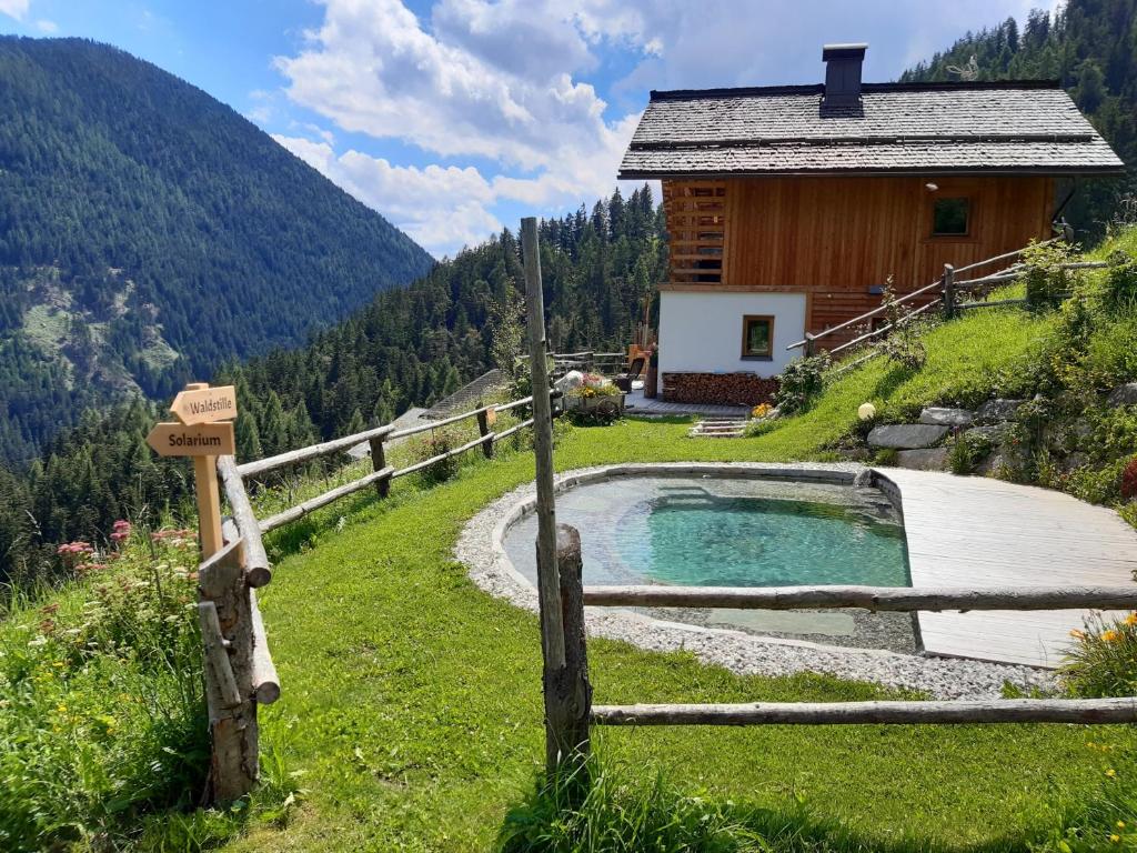 a cabin in the mountains with a hot tub in front at Naturchalet in San Vigilio Di Marebbe