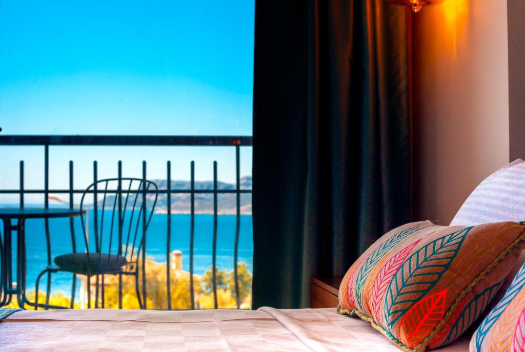 a bedroom with a view of the ocean from a balcony at Molino Hotel in Kaş