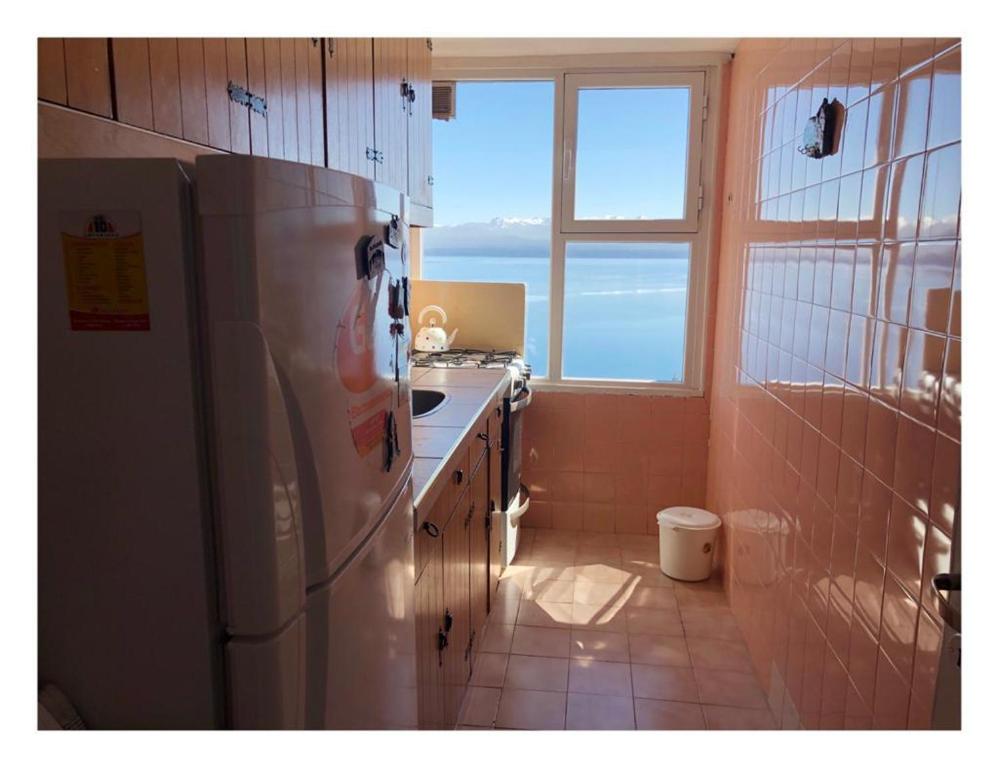 a kitchen with a refrigerator and a sink and a window at Departamento en Bariloche in San Carlos de Bariloche