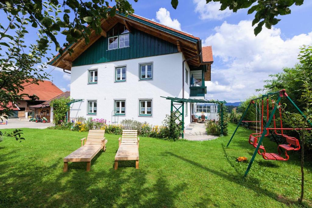 ein Haus mit einem Spielplatz und einer Schaukel in der Unterkunft Siglbauernhof in Laufen