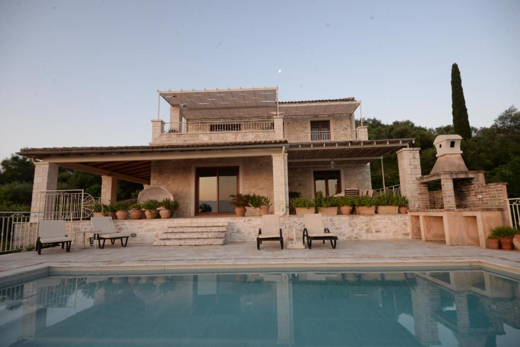 a house with a swimming pool in front of a house at Villa Melanthi Kassiopi Corfu in Kassiopi