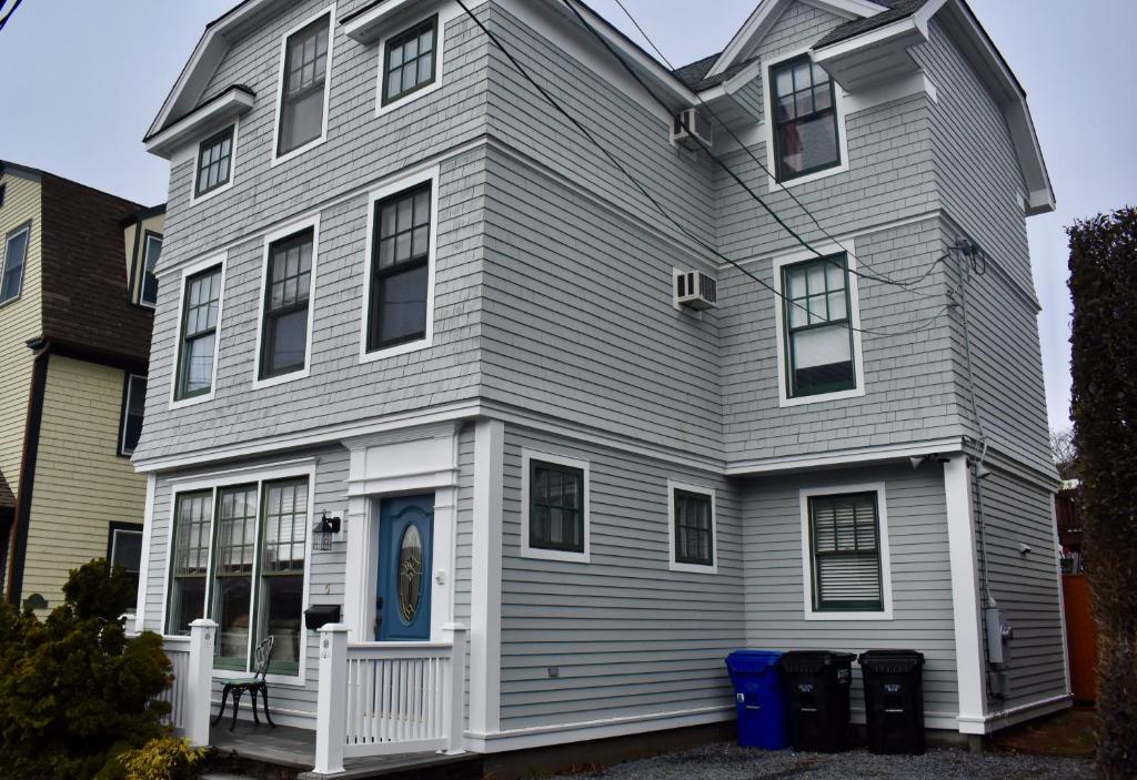 a gray house with a blue door at Modern Cottage in Downtown NPT-Waites Wharf Cottage in Newport
