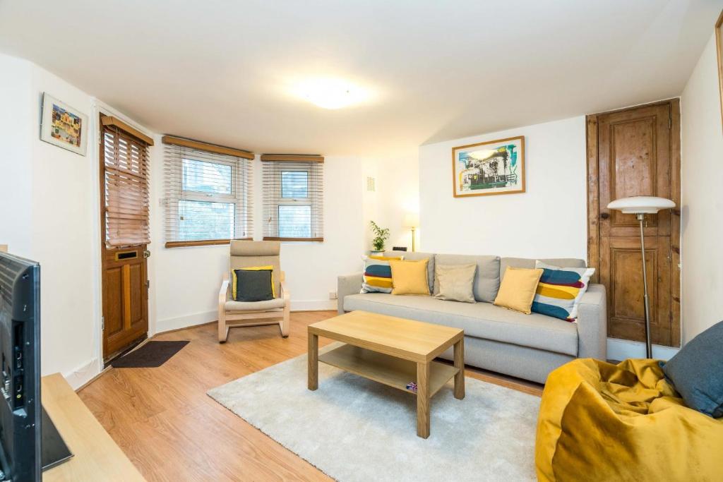 a living room with a couch and a table at NEW Stylish 1 Bedroom Flat with Garden London in London