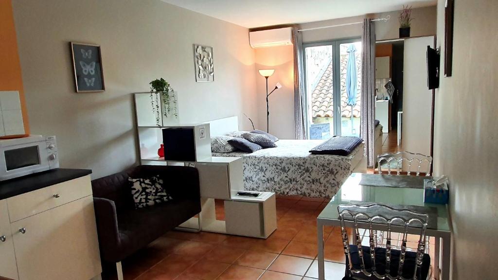 een slaapkamer met een bed en een bureau met een magnetron bij Studios du Rempart in Avignon