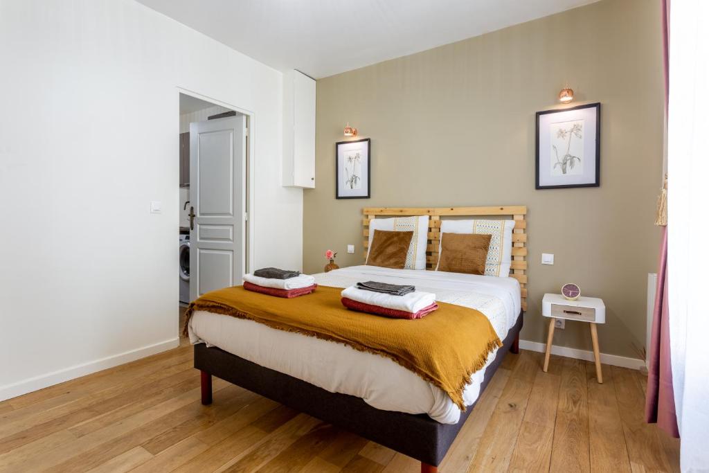 a bedroom with a large bed with two pillows on it at StayLib - Lovely 2 rooms porte de Montmartre in Saint-Ouen