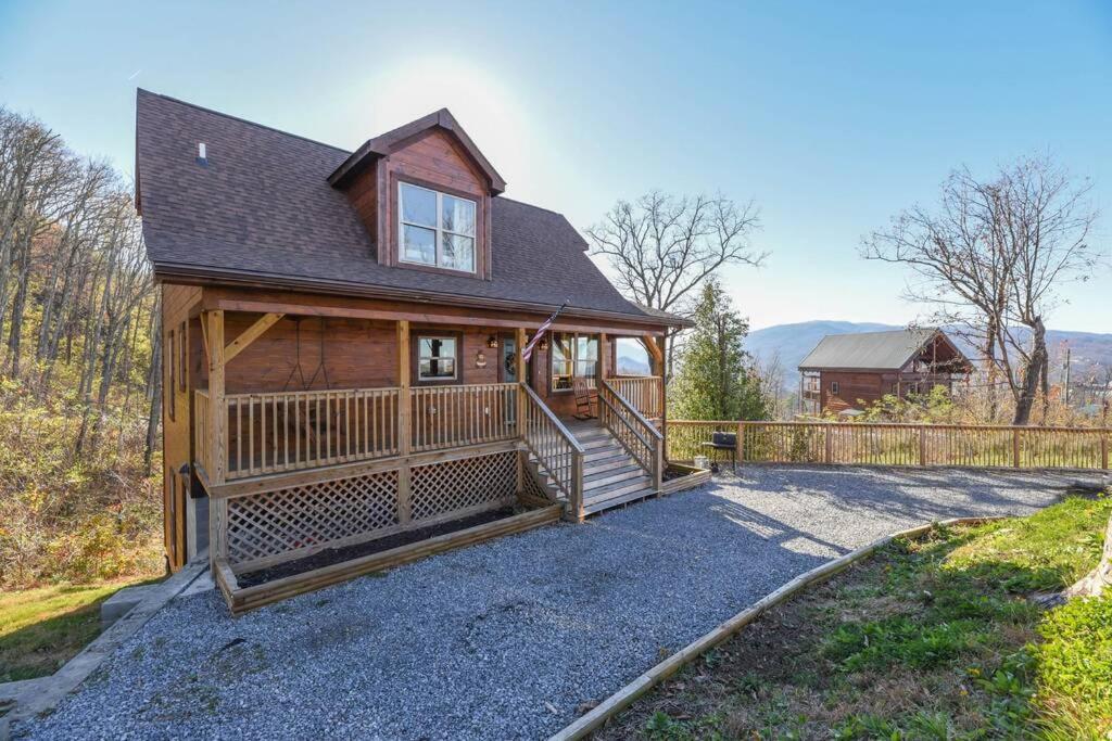 a large home with a porch and a fence at Walnut Ridge Cabin. Sleeps 7-11! Hot tub, pool table, minutes to downtown Gatlinburg! in Gatlinburg