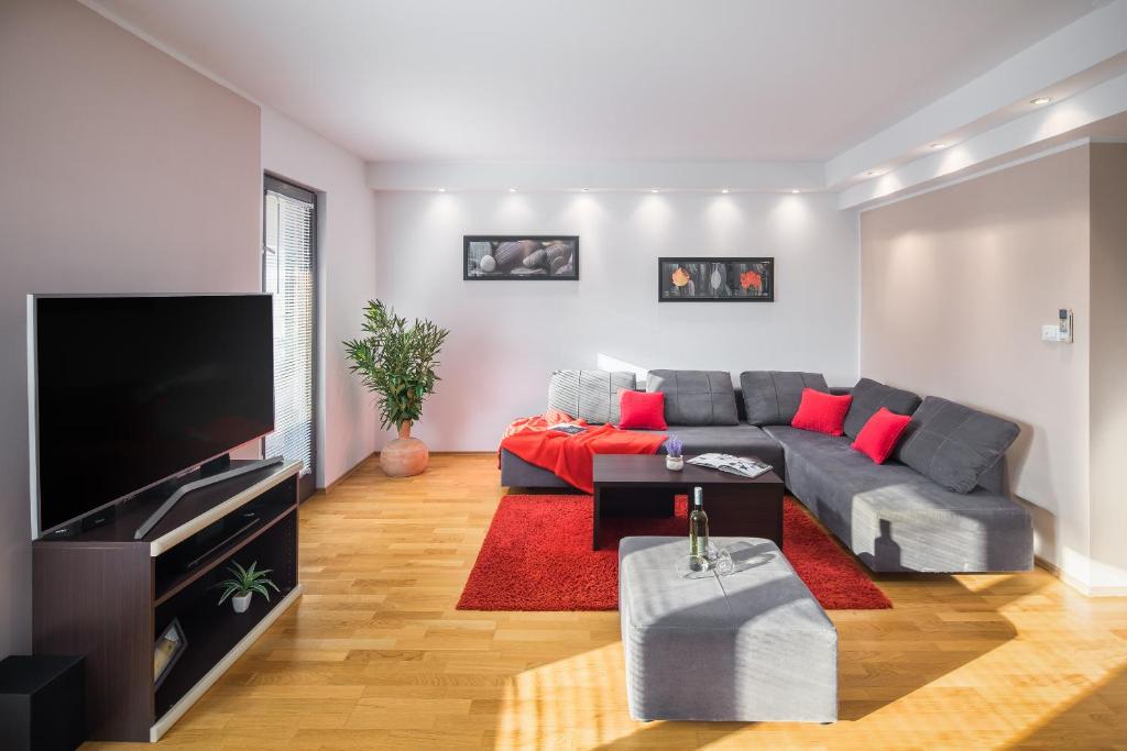 a living room with a couch and a flat screen tv at Urban Premium Apartments in Poreč