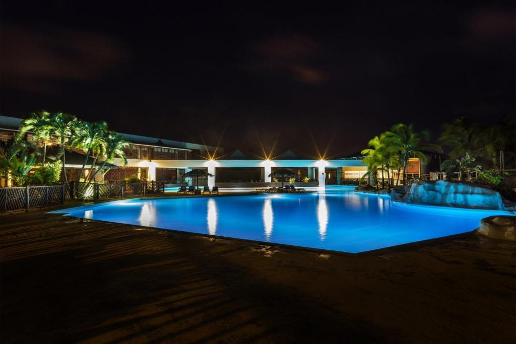 duży basen w nocy z oświetleniem w obiekcie F3 _ Kaz ananas passion au Manganao w mieście Saint-François