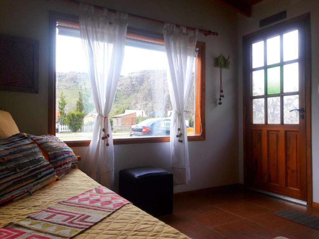 a bedroom with a bed and a window at Cabañas Paso de Viento in El Chalten