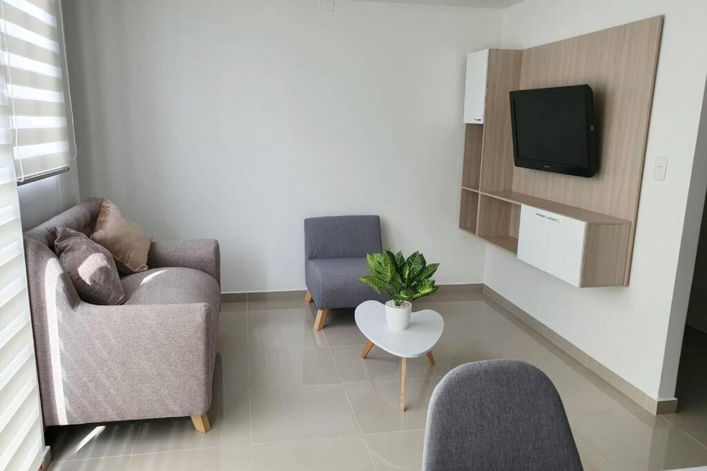 ein Wohnzimmer mit 2 Stühlen und einem TV in der Unterkunft Apartamento Completo, Perfecto para tus viajes in Cúcuta