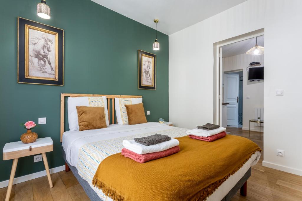 a bedroom with a bed with two pillows on it at StayLib - APPARTEMENT 2 PIECES AUX PORTES DE PARIS in Saint-Ouen