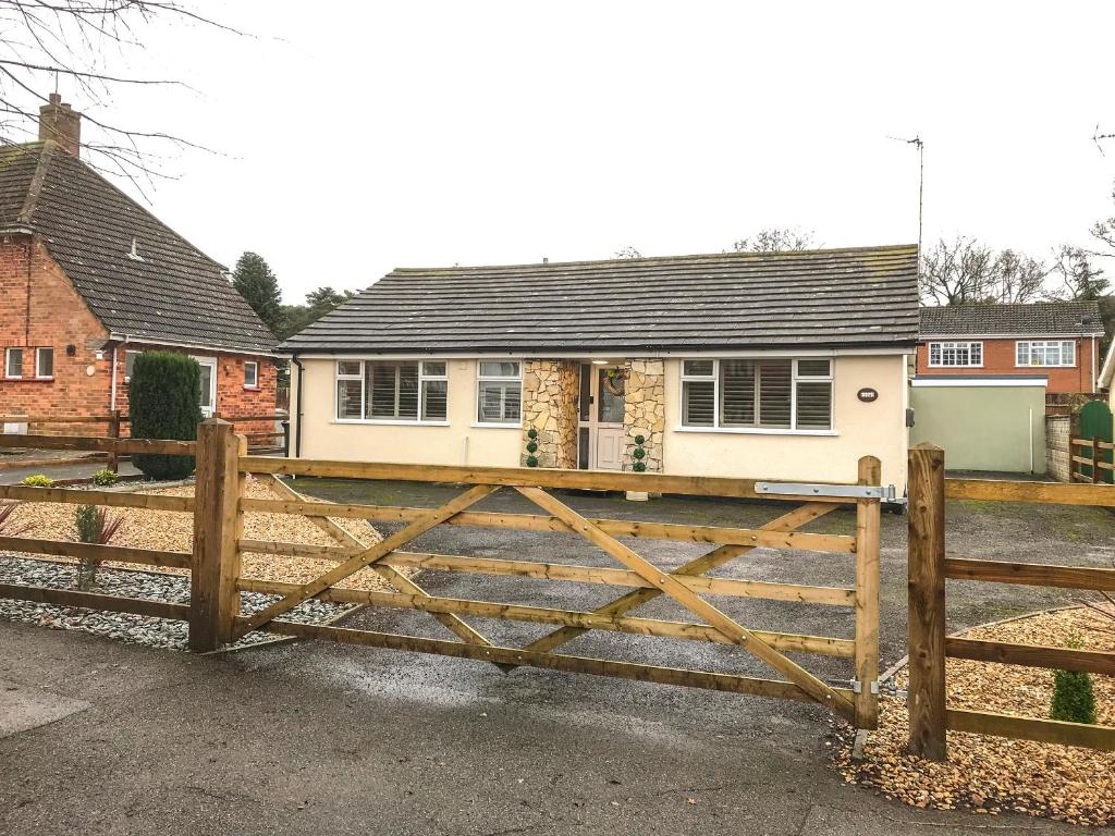 una valla de madera frente a una casa en Giggling Goose Cottage, en Woodhall Spa