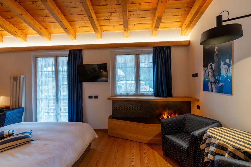 um quarto com uma cama e uma lareira em Sport Hotel Alpina em Madesimo