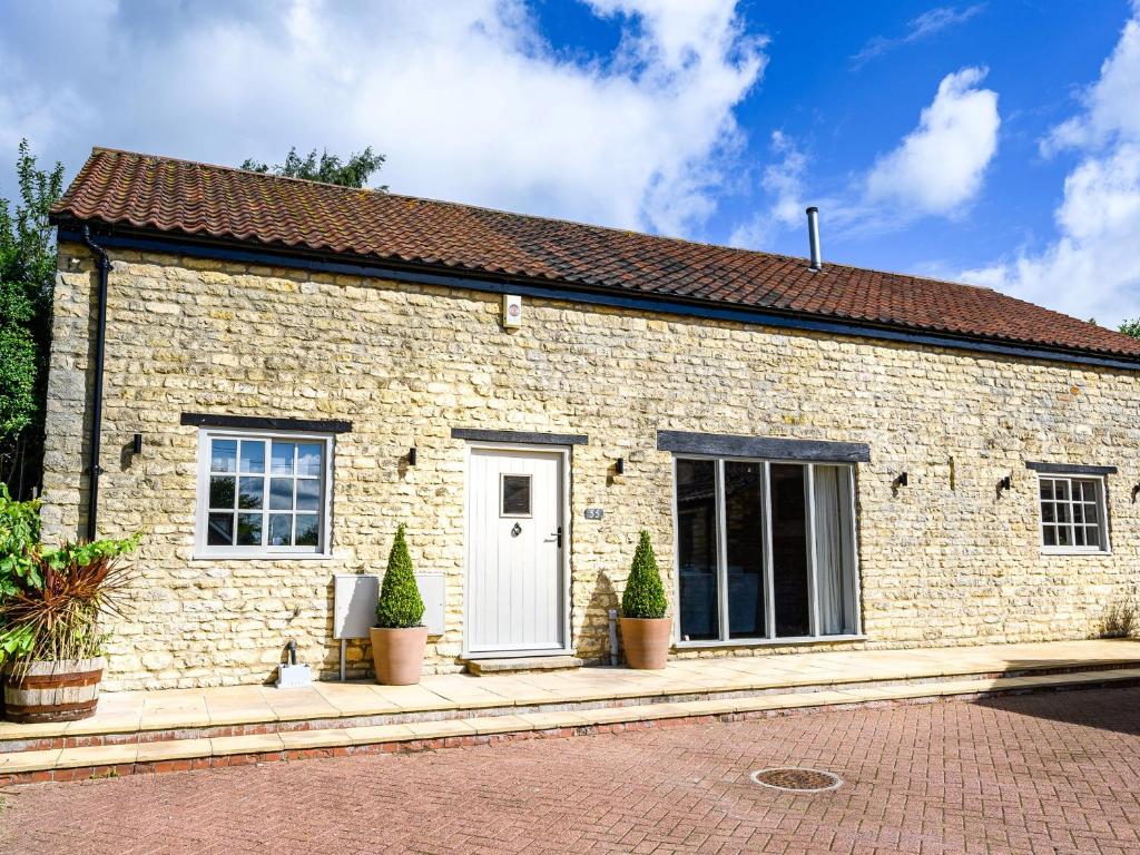 a brick house with plants in front of it at Farmcourt Barn 55 Eastfield Lane in Lincoln