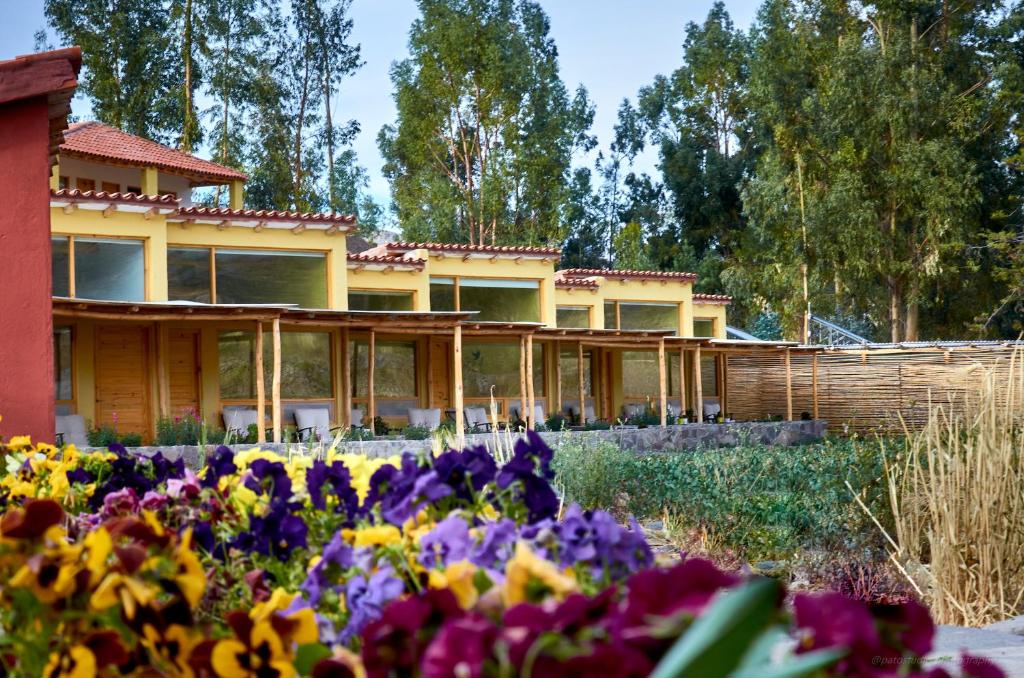 uma casa com flores em frente em Killawasi Lodge em Yanque