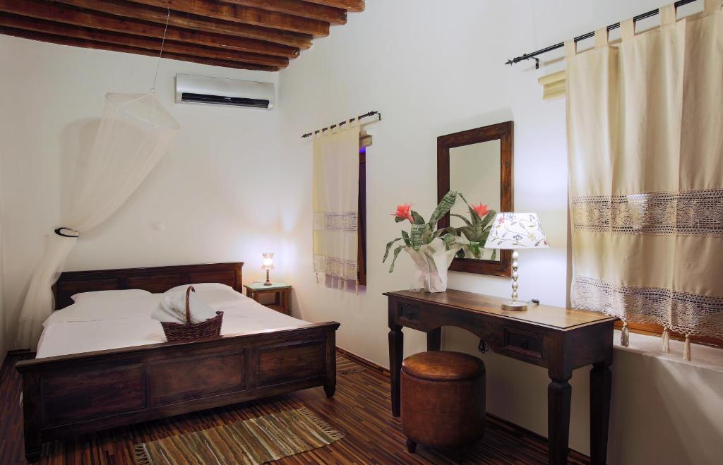 a bedroom with a bed and a desk and a mirror at Lindos Boutique - Adults Only in Líndos