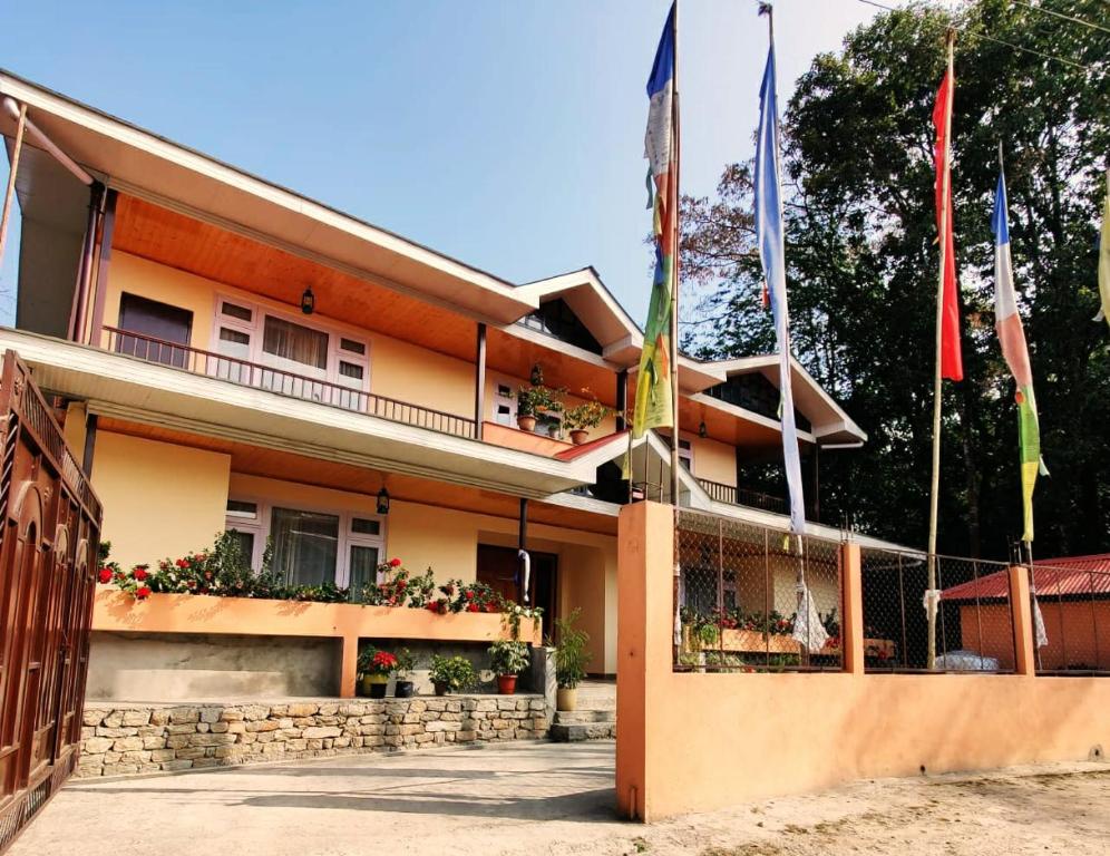 a building with flags in front of it at Martam Village Homestay in Gangtok