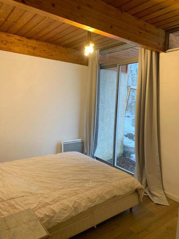 Cama ou camas em um quarto em Barcelonnette location avec jardin