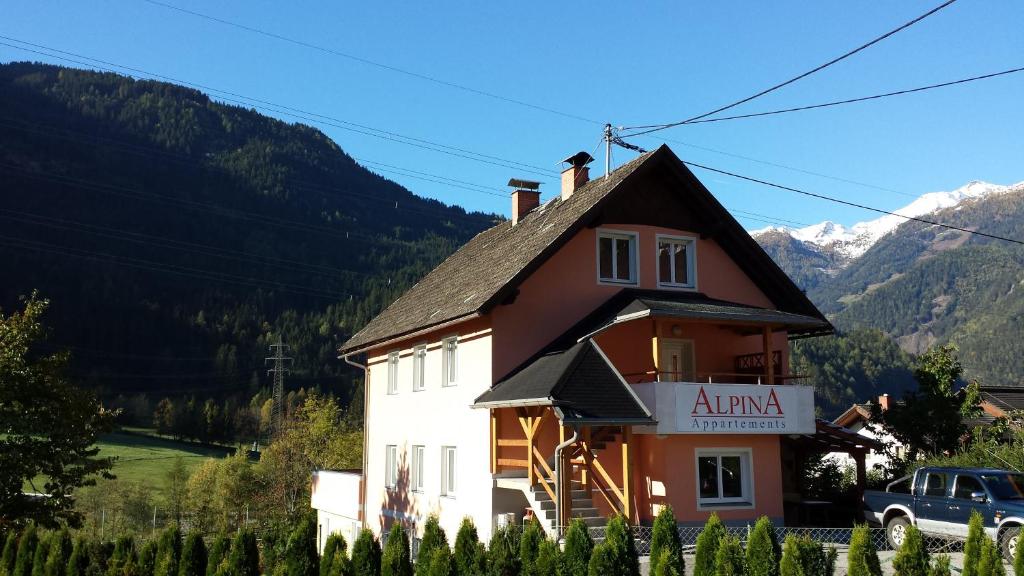 a building with a sign on the side of it at Appartementhaus Alpina in Flattach