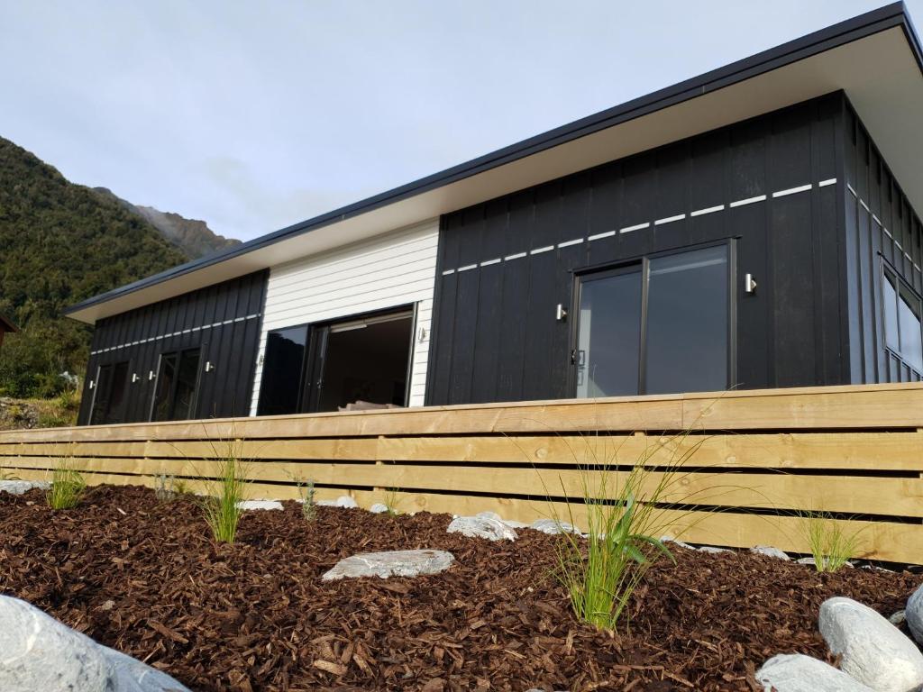 a home with a black and white house at Stony Creek, 3 bedroom home, Franz Josef in Franz Josef