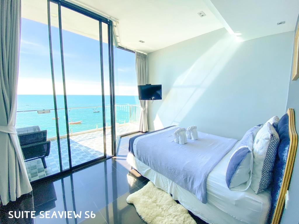 a bedroom with a bed and a view of the ocean at Sea Sand Trees in Bangsaen