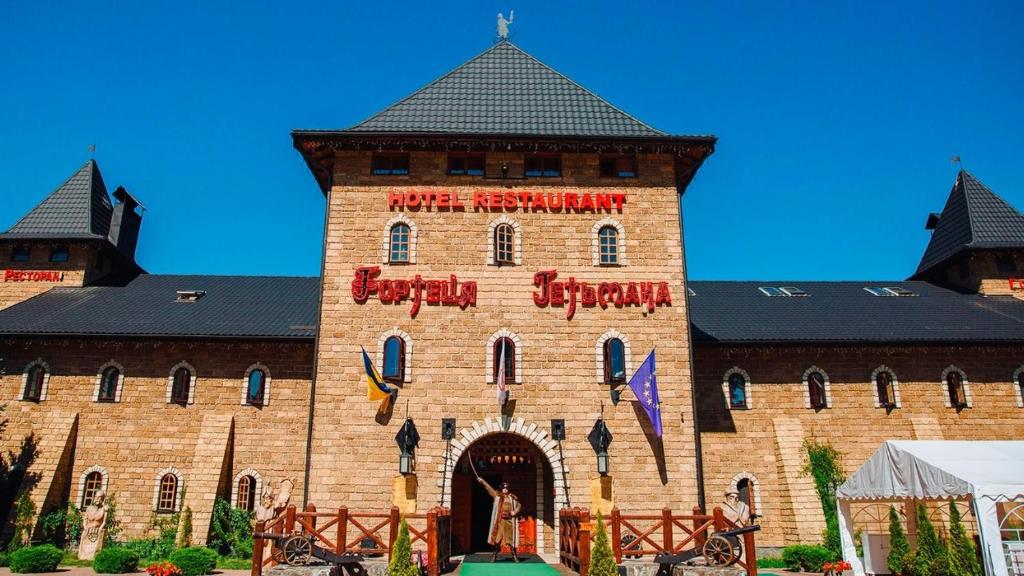 a large brick building with a sign on it at Hotel Fortetsya Hetmana in Hatne