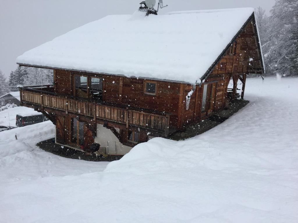 dom pokryty śniegiem i śniegiem na dachu w obiekcie Le Caribou w mieście Saint-Gervais-les-Bains